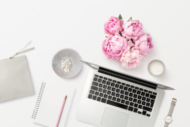 bright feminine workspace with open laptop computer, office supp bright feminine workspace with open laptop computer, office supp